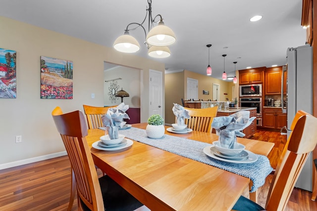 dining space featuring recessed lighting, baseboards, and wood finished floors