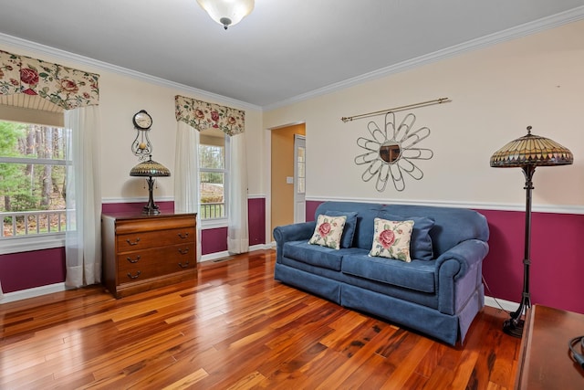 living area with crown molding, baseboards, and wood finished floors
