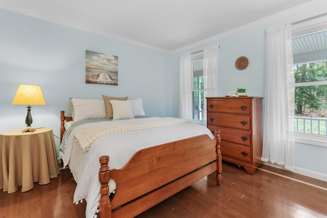 bedroom featuring wood-type flooring, ornamental molding, and baseboards