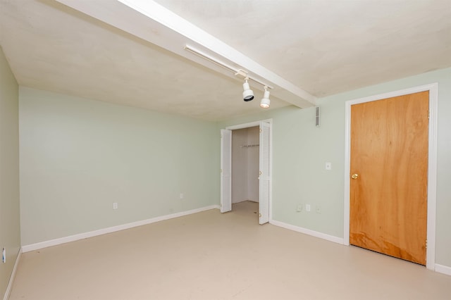 empty room with finished concrete floors, baseboards, and visible vents