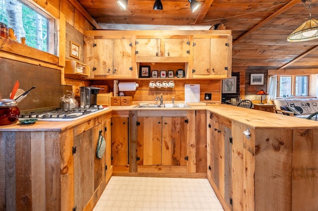 kitchen featuring wooden ceiling, a sink, a wealth of natural light, and light floors