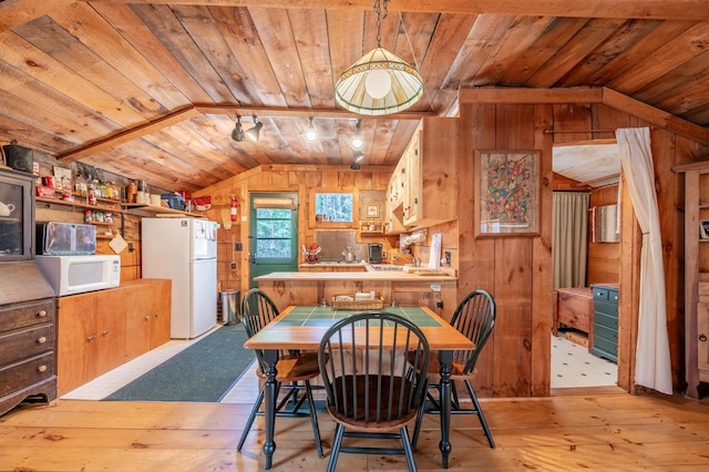 dining space featuring wooden walls, wooden ceiling, wood-type flooring, and lofted ceiling