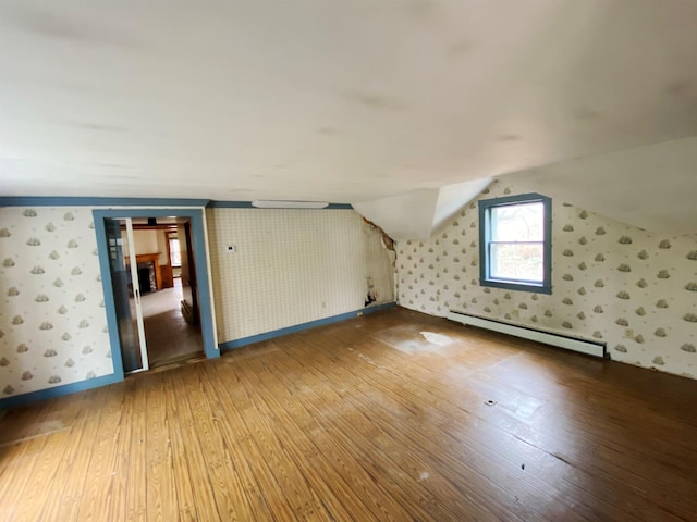 bonus room featuring baseboard heating, hardwood / wood-style floors, and wallpapered walls