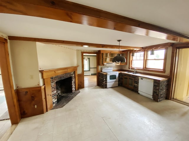 kitchen featuring white appliances, a sink, a brick fireplace, and a wealth of natural light