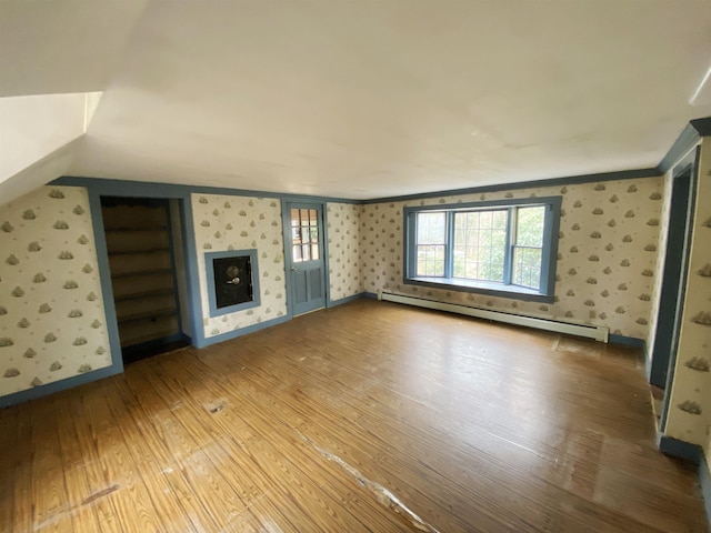 unfurnished living room featuring crown molding, baseboards, wallpapered walls, wood finished floors, and a baseboard radiator