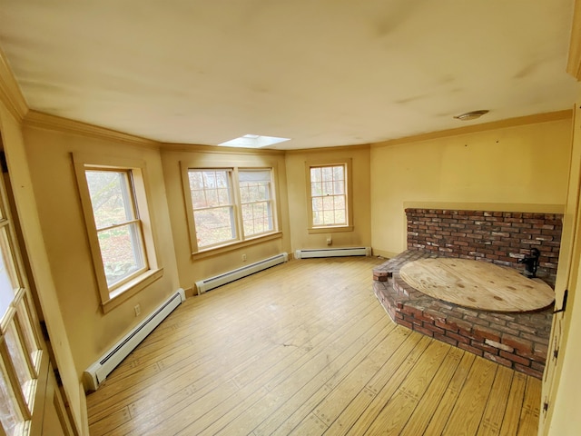 unfurnished room featuring ornamental molding, baseboard heating, and light wood-type flooring