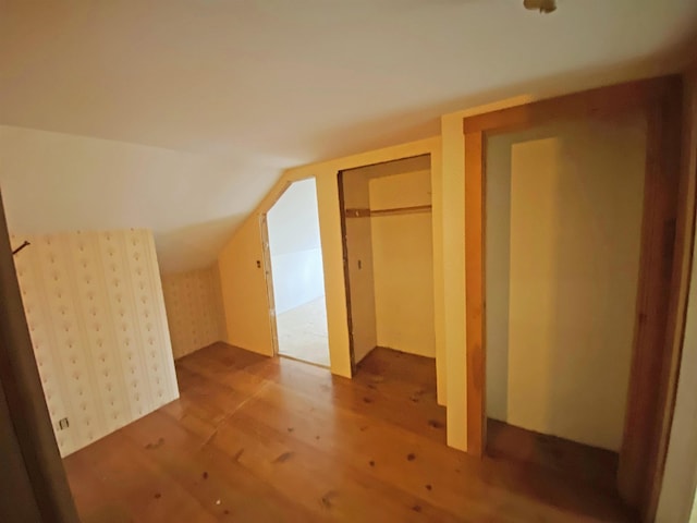 bonus room with wood finished floors and vaulted ceiling