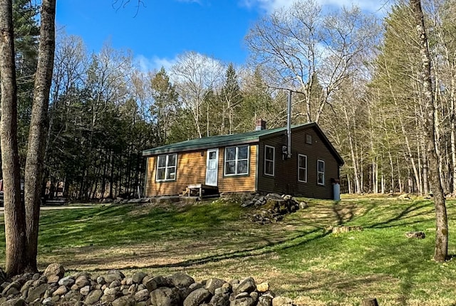 view of front facade featuring a chimney and a front yard