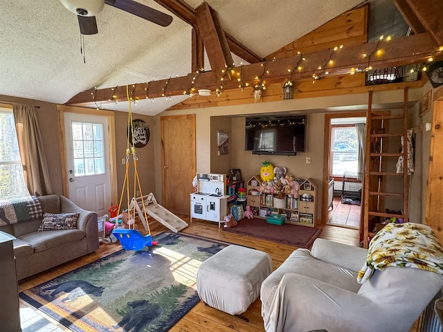 living room featuring a textured ceiling, ceiling fan, lofted ceiling, and hardwood / wood-style floors