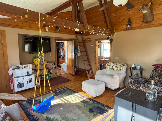 living area with lofted ceiling with beams and wood finished floors