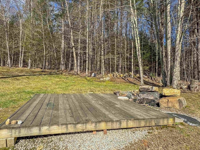 wooden deck featuring a yard and a forest view
