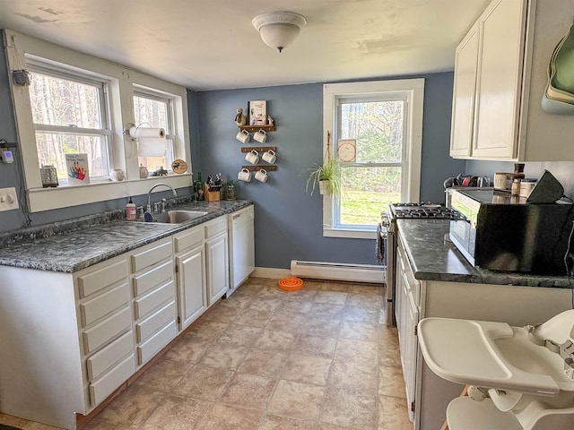 kitchen featuring a sink, a baseboard radiator, plenty of natural light, and white cabinetry