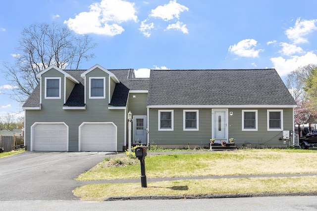 view of front of house featuring a front lawn, roof with shingles, entry steps, an attached garage, and driveway