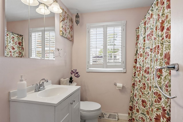 bathroom with toilet, visible vents, a wealth of natural light, and vanity