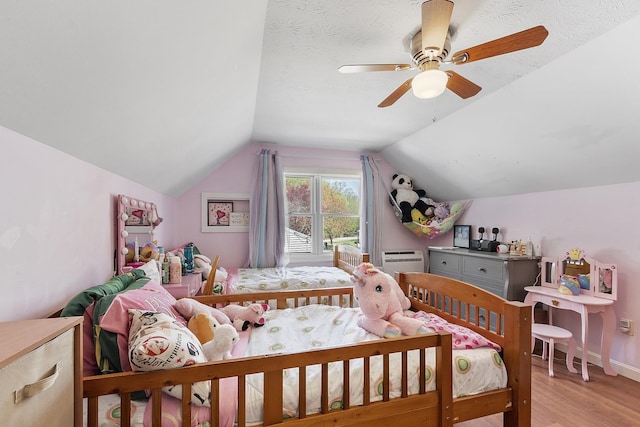 bedroom with light wood-style floors, ceiling fan, and lofted ceiling