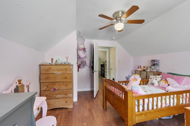 bedroom featuring baseboards, ceiling fan, wood finished floors, and vaulted ceiling
