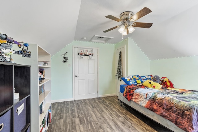 bedroom with baseboards, ceiling fan, wood finished floors, and lofted ceiling