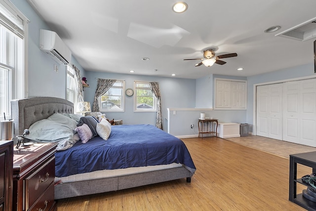 bedroom featuring a ceiling fan, visible vents, a wall mounted air conditioner, light wood-style floors, and recessed lighting