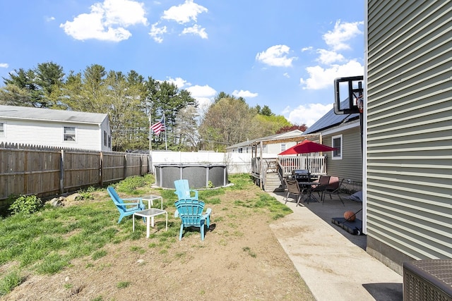 view of yard featuring a patio, a fenced in pool, a fenced backyard, and a deck