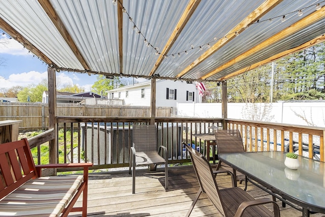wooden deck with a fenced backyard and outdoor dining space