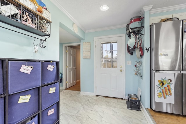 interior space featuring baseboards, ornamental molding, freestanding refrigerator, and marble finish floor