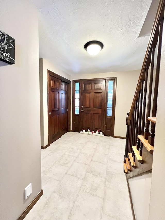 12 Nathaniel Dr, Amherst, NH 03031 - entrance foyer with baseboards, a textured ceiling, and stairway