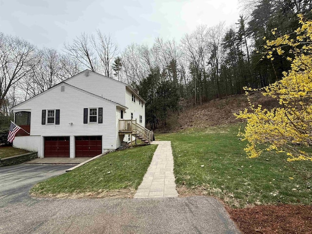 12 Nathaniel Dr, Amherst, NH 03031 - view of side of home featuring a garage, a yard, driveway, and stairway