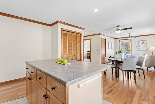 kitchen featuring ornamental molding, ceiling fan, a center island, recessed lighting, and light wood-type flooring