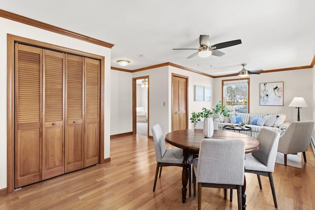 dining space with light wood-style floors, baseboards, ornamental molding, and a ceiling fan