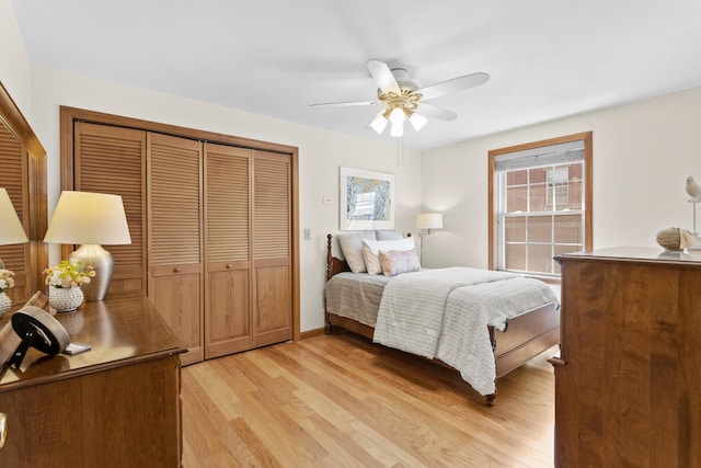 bedroom with a ceiling fan, light wood-style floors, multiple windows, and a closet