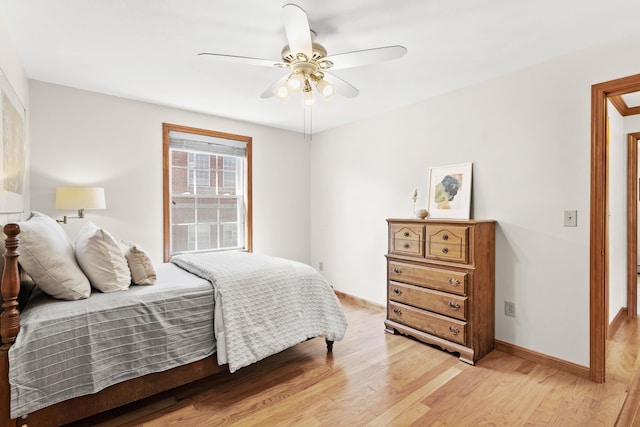 bedroom featuring baseboards, a ceiling fan, and light wood-style flooring