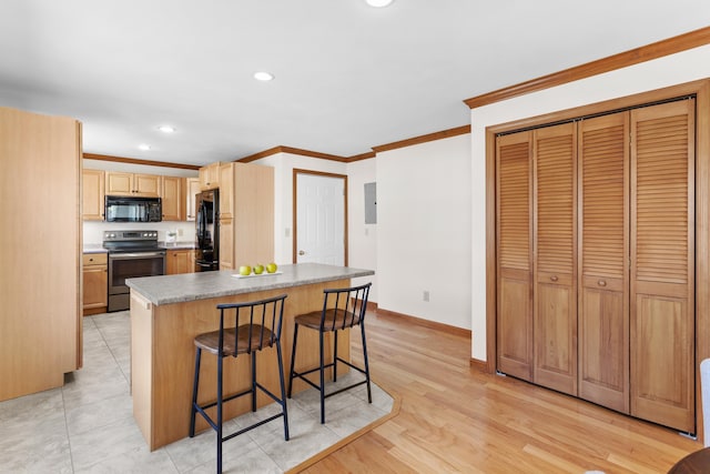 kitchen with ornamental molding, a breakfast bar, baseboards, recessed lighting, and black appliances