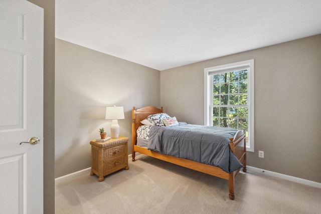 bedroom featuring baseboards and light carpet