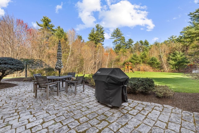 view of patio / terrace featuring outdoor dining area, a playground, and area for grilling