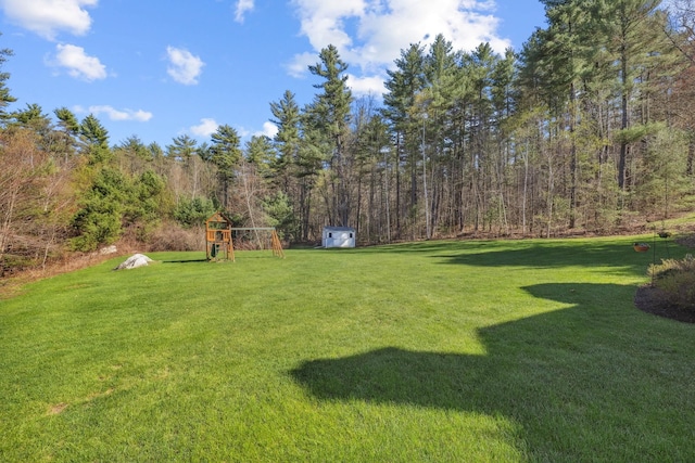 view of yard with a forest view and a playground