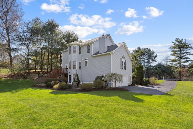 view of home's exterior featuring a yard, an attached garage, stairs, and aphalt driveway