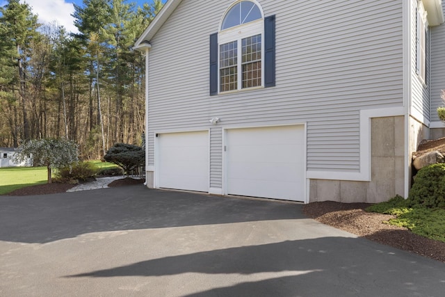 view of home's exterior featuring a garage and aphalt driveway