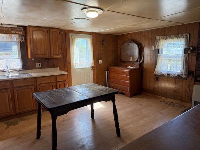kitchen with light countertops, brown cabinetry, a sink, and light wood-type flooring