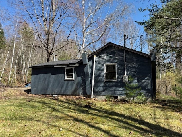 view of side of property with a yard and a chimney