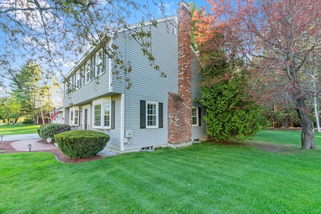 view of home's exterior with a yard and a chimney