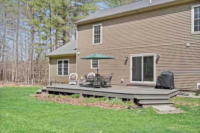 rear view of house with a shingled roof, a yard, and a deck
