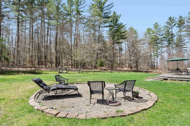 view of yard featuring fence, a wooden deck, and a fire pit
