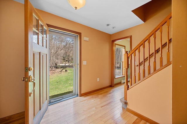 entryway featuring baseboards, baseboard heating, hardwood / wood-style flooring, and stairway
