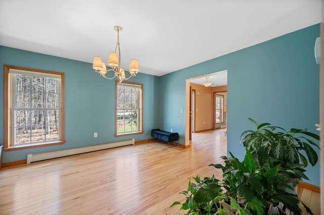 unfurnished dining area featuring baseboards, baseboard heating, hardwood / wood-style floors, and a chandelier