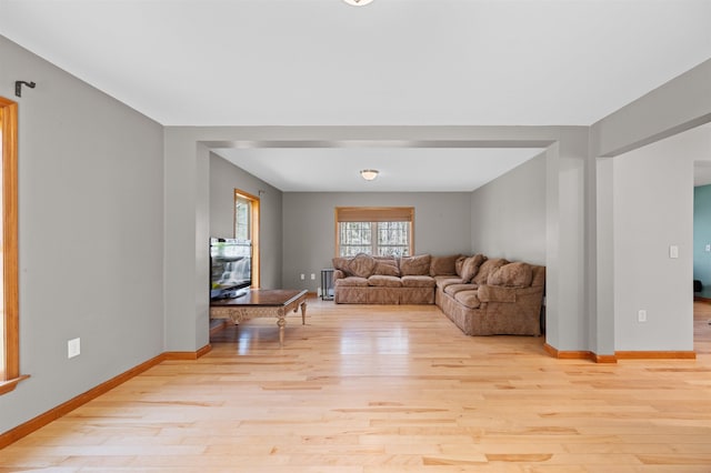 living room featuring baseboards and light wood-type flooring