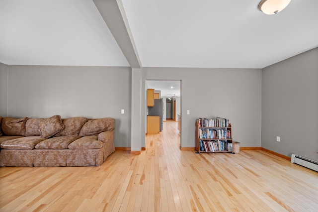 living area featuring light wood-type flooring, a baseboard radiator, and baseboards