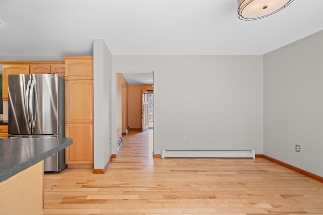 kitchen with freestanding refrigerator, baseboards, light wood-style flooring, and a baseboard radiator