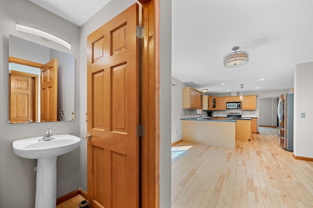 bathroom with baseboards, a sink, and hardwood / wood-style floors