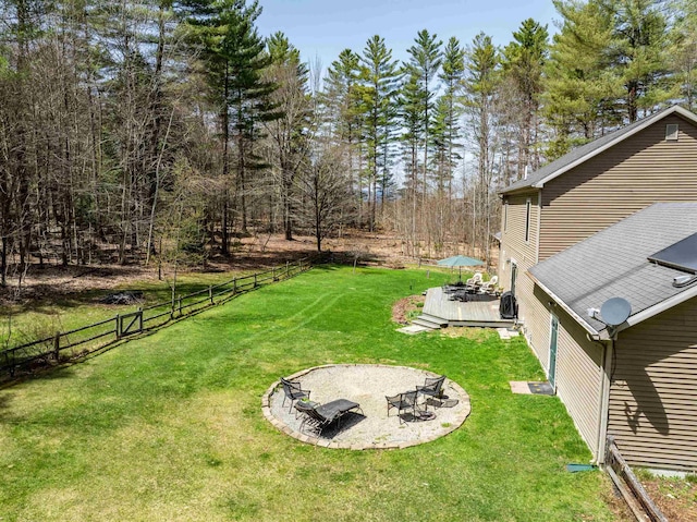 view of yard featuring an outdoor fire pit, a wooden deck, and fence