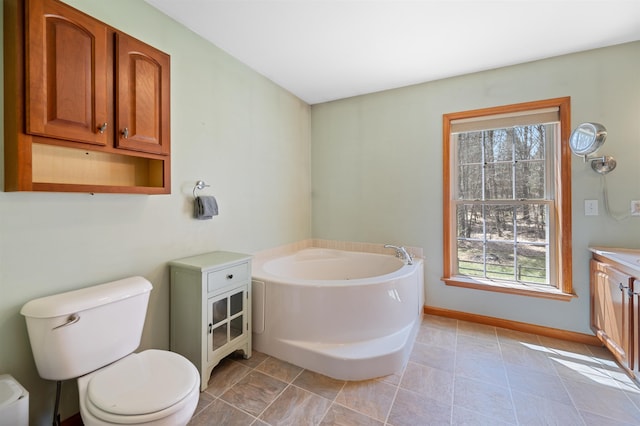 full bathroom featuring vanity, baseboards, toilet, and a bath